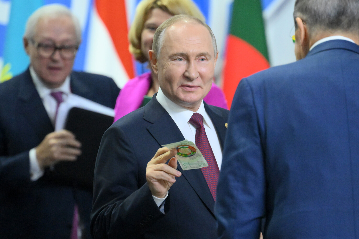 Владимир Путин с сувенирной банкнотой. Фото: РИА Новости
